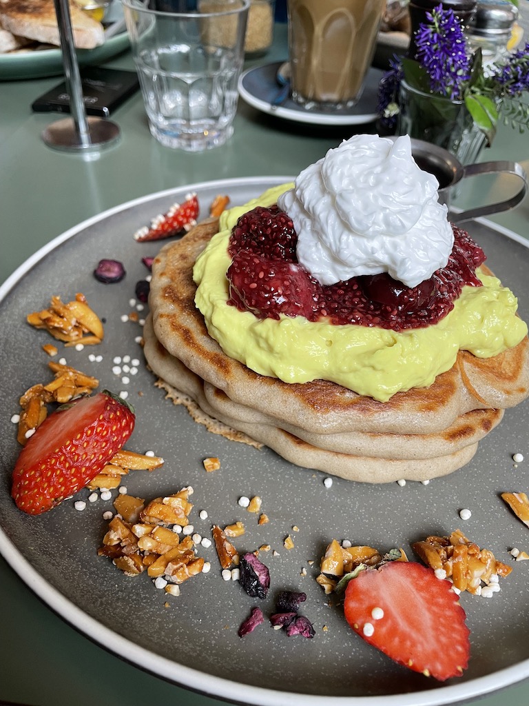 Breakfast pancakes, topped with berry compote, chia seed yogurt and garnished with strawberries and "granola stuff"- Bespoke Kitchen, Queenstown