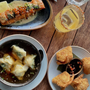 A Birdseye shot of various plates of food and a mango chilli margarita at King of Snake- an Asian-fusion restaurant in Central Christchurch, New Zealand.