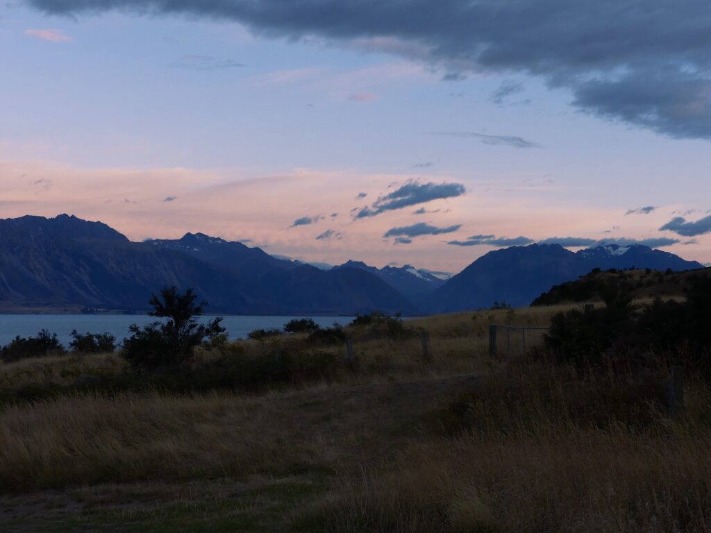 The sun rising from behind the mountains and the sky turning a beautiful light pink