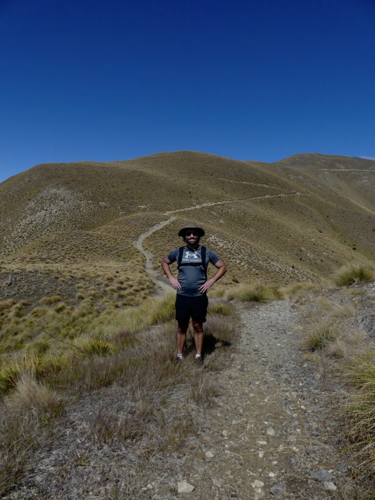 Ben stood in shorts and a hat whilst walking the track