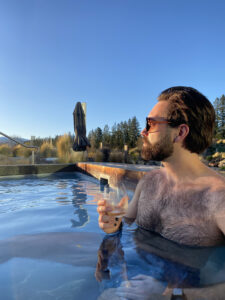 Ben enjoying a drink in one of the best outdoor hot pools on the South Island of New Zealand- Ōpuke Hot Pools, Methven.